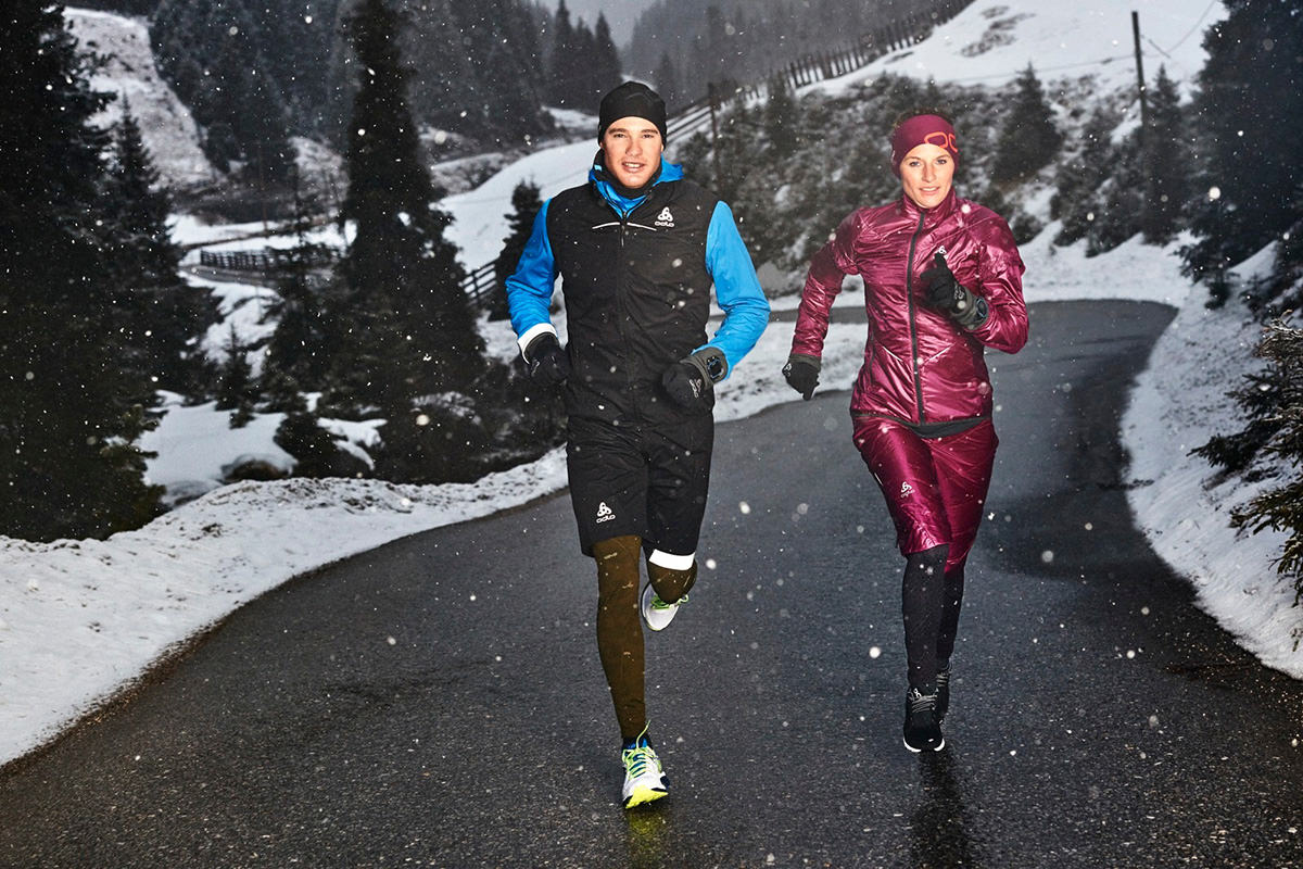 A man and woman running in the snow