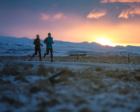 Runners running in a snowy field