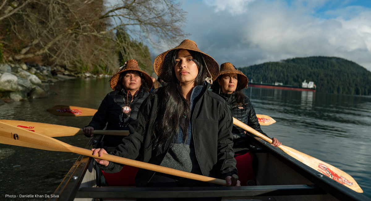 Charlene Aleck, Kayah George and Deborah Parker take their rightful place at the bow of a canoe. They each wear a traditional, handwoven cedar-bark hat, a mark of pride in their cultural identity as well as their reputation as formidable paddlers.