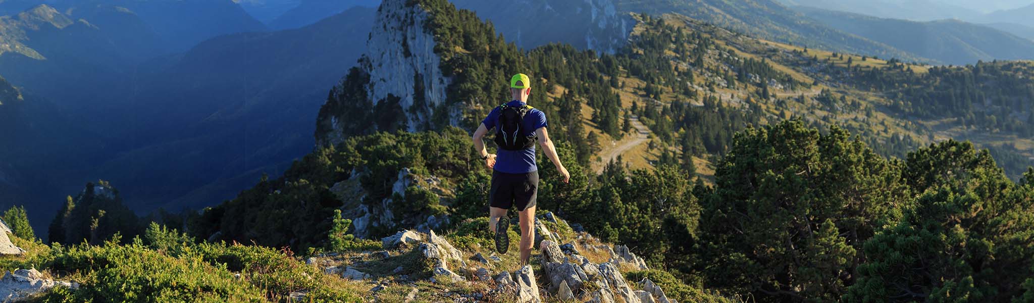 A man trail running on a hilly landscape