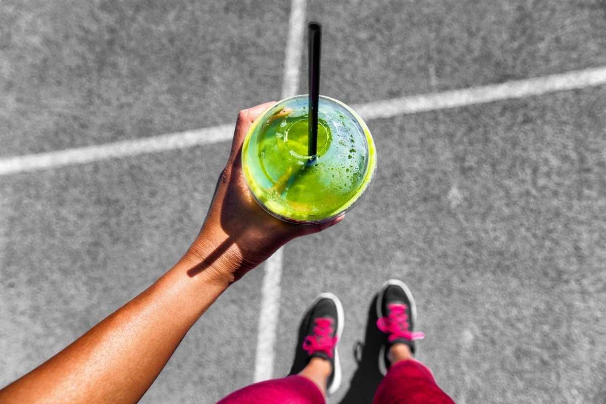 An image of a woman drinking a smoothie post-run