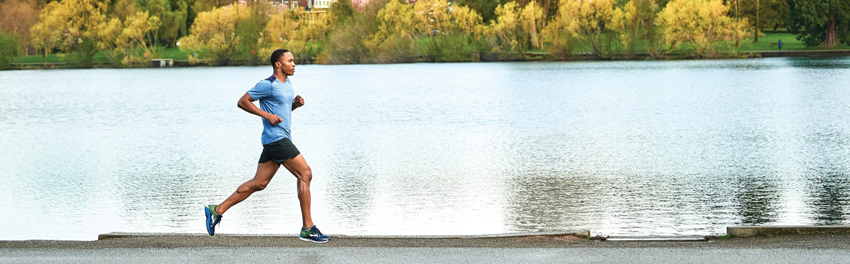 A person running past a lake in Brooks running shoes 