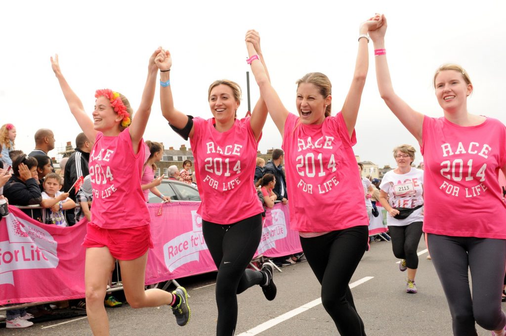 Four woman holding hands after completing Race For Life 