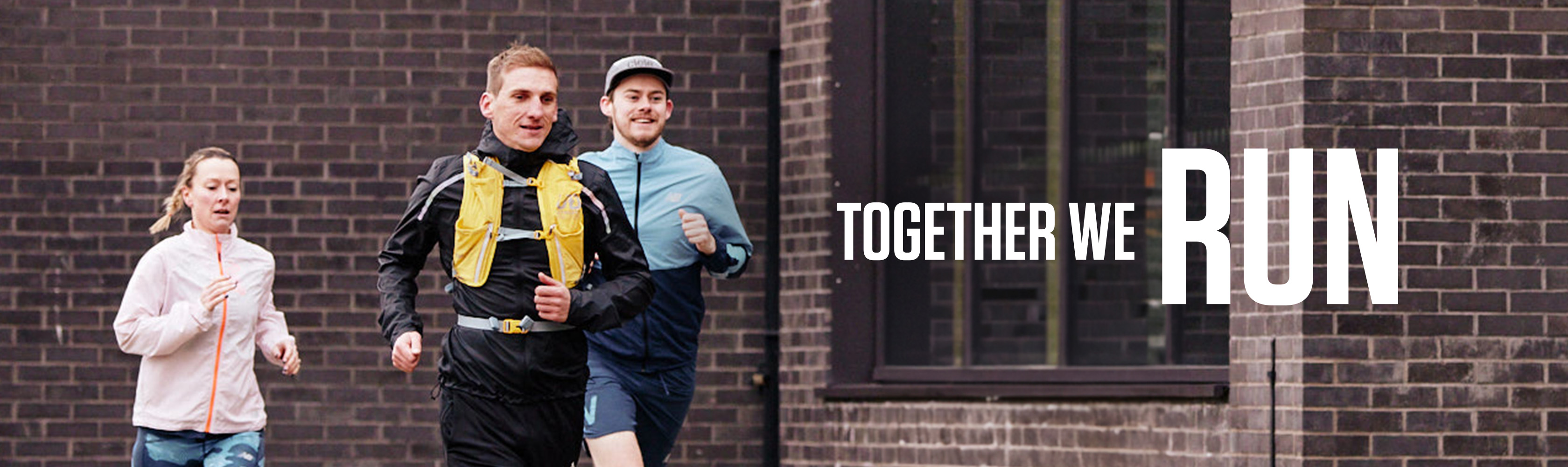 Three people running together in an urban area with the words: Together We RUN