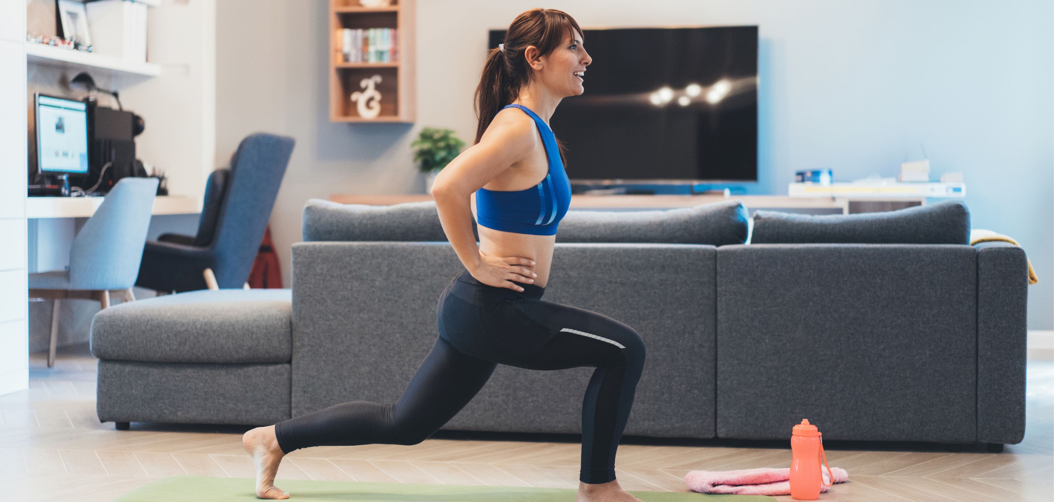 A woman doing lunges in her living room
