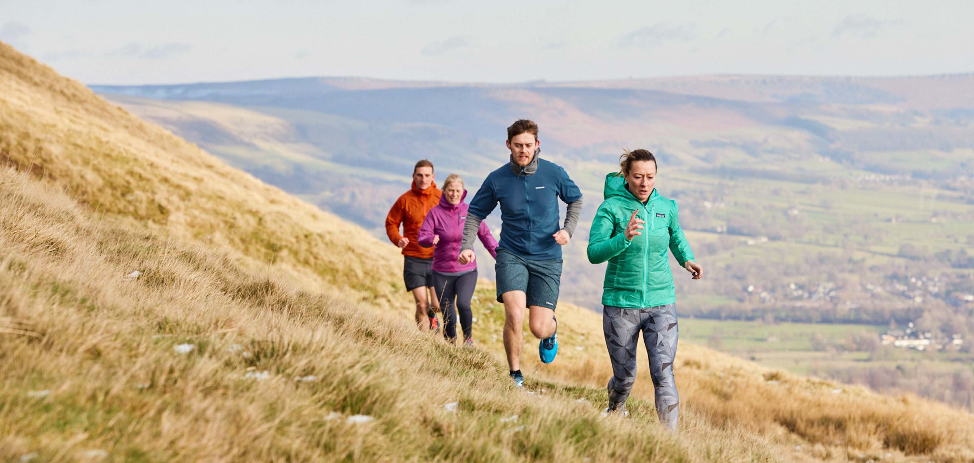 People are trail running, wearing running shoes and running kit.