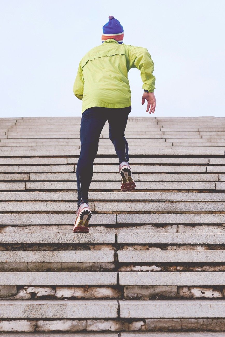 A person running up steps in the winter in their gtx running shoes