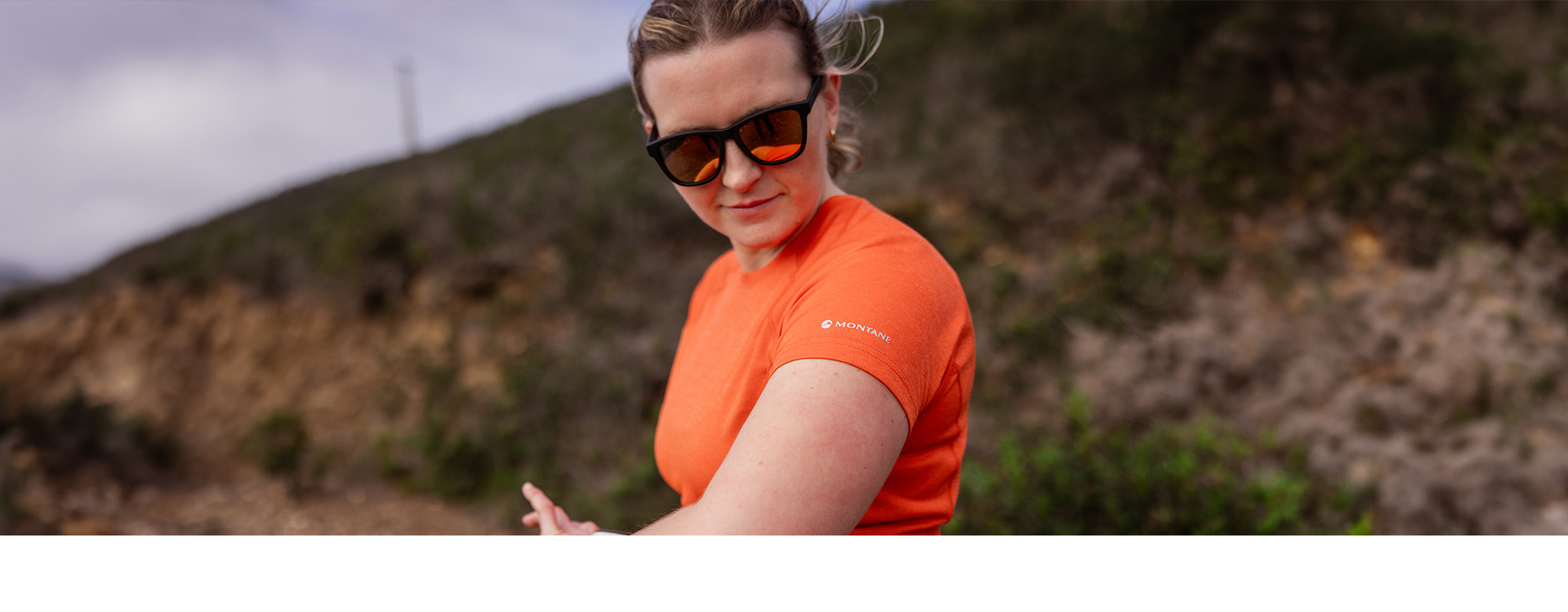 A person on a trail run wearing sunglasses
