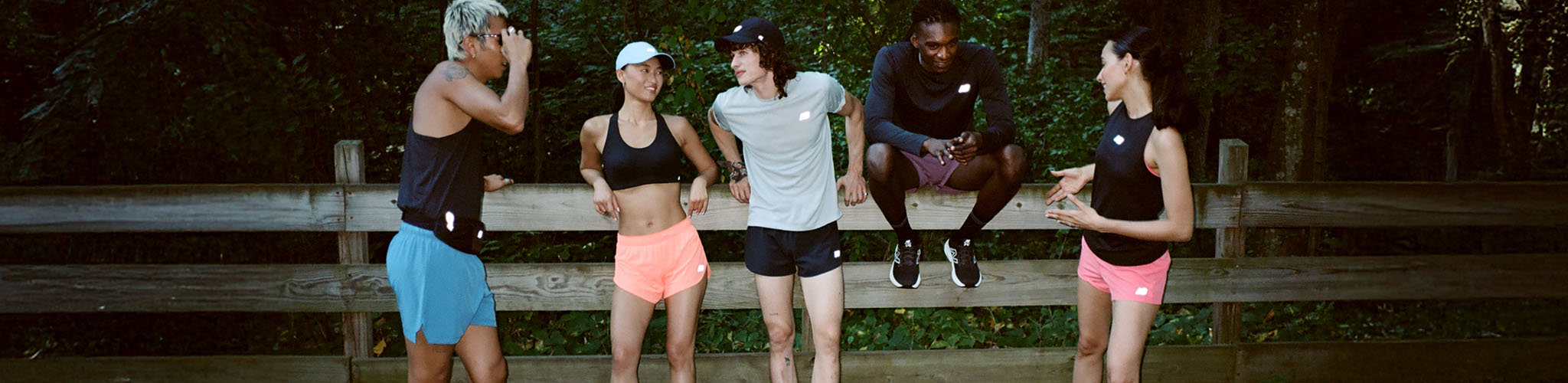 Shop New Balance clothing. A group of runners in summer cloting resting after a race
