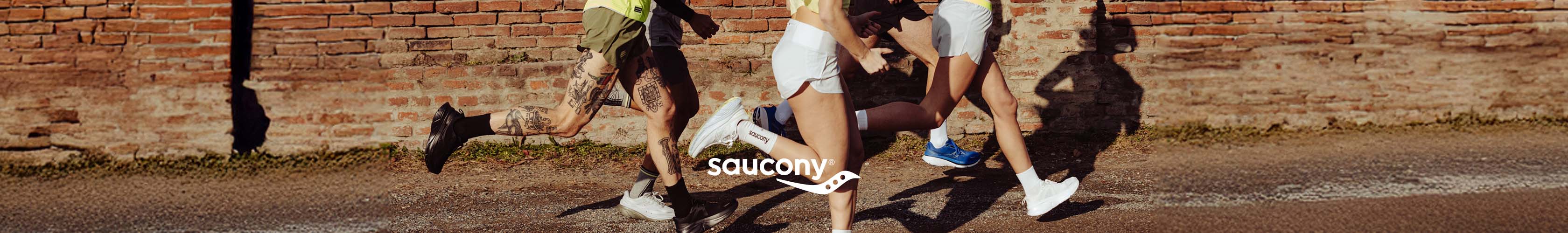 Shop Saucony.  Group of people running o the road in Saucony gear