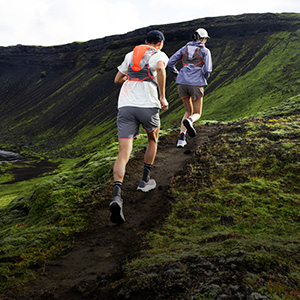 Shop Accessories. Two runners with backpack running up the hill