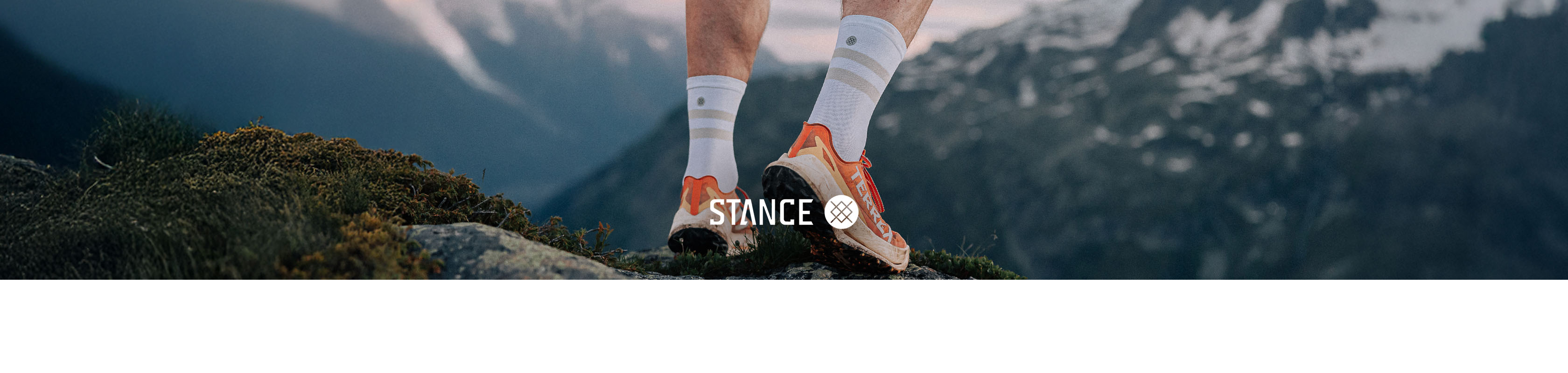 Shop Stance Socks. A pearson standing on a rocky hill top