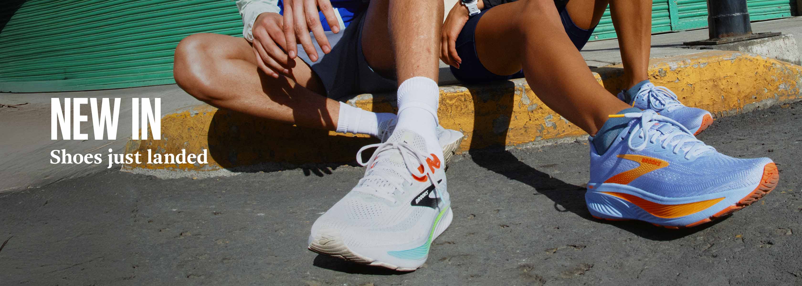 Shop new arrivals on Runners need. Two people in running shoes sitting on the edge of the road