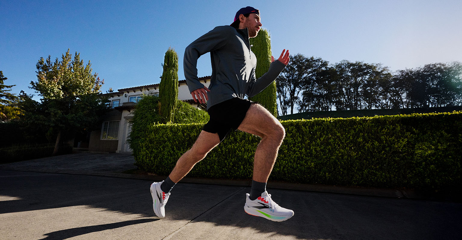 Shop men's running gear. A man running on a street