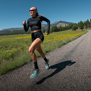 Shop Race essentials. A woman running on a dirth path