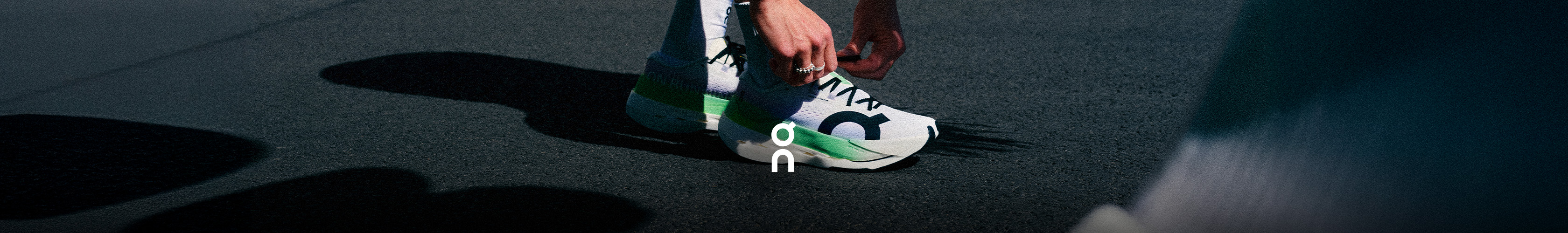 Shop ON cloudboom max. A runner is tying laces on his shoes