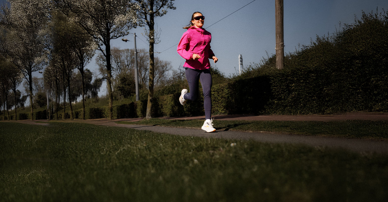 Shop women's running gear. A woman running on the street