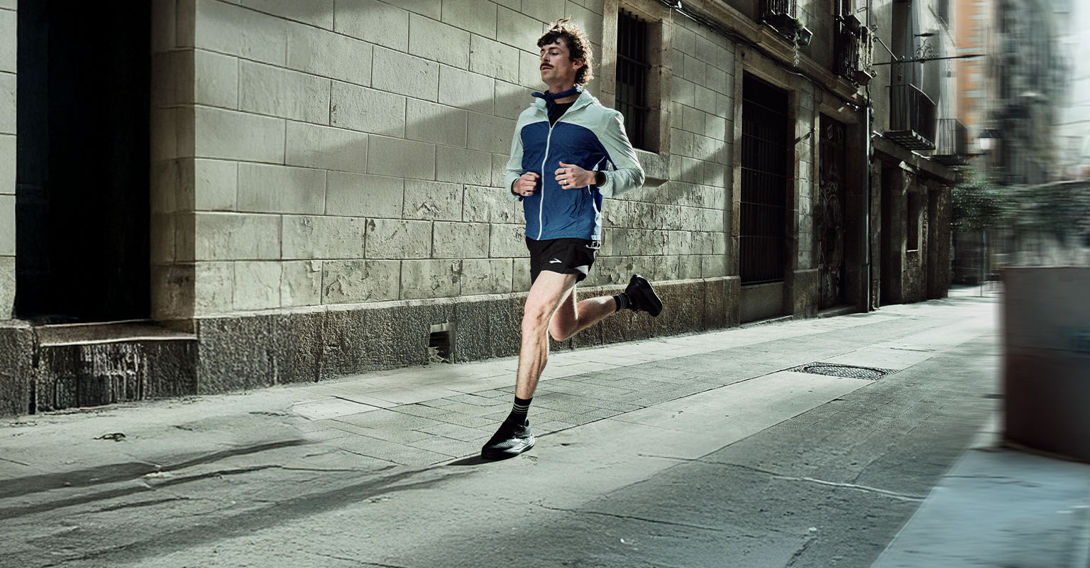 Shop men's running gear. A man running on a street