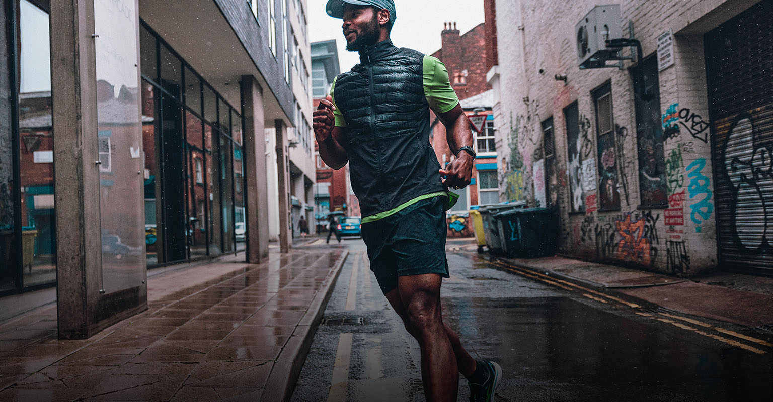 Shop men's running gear. A man running on a street