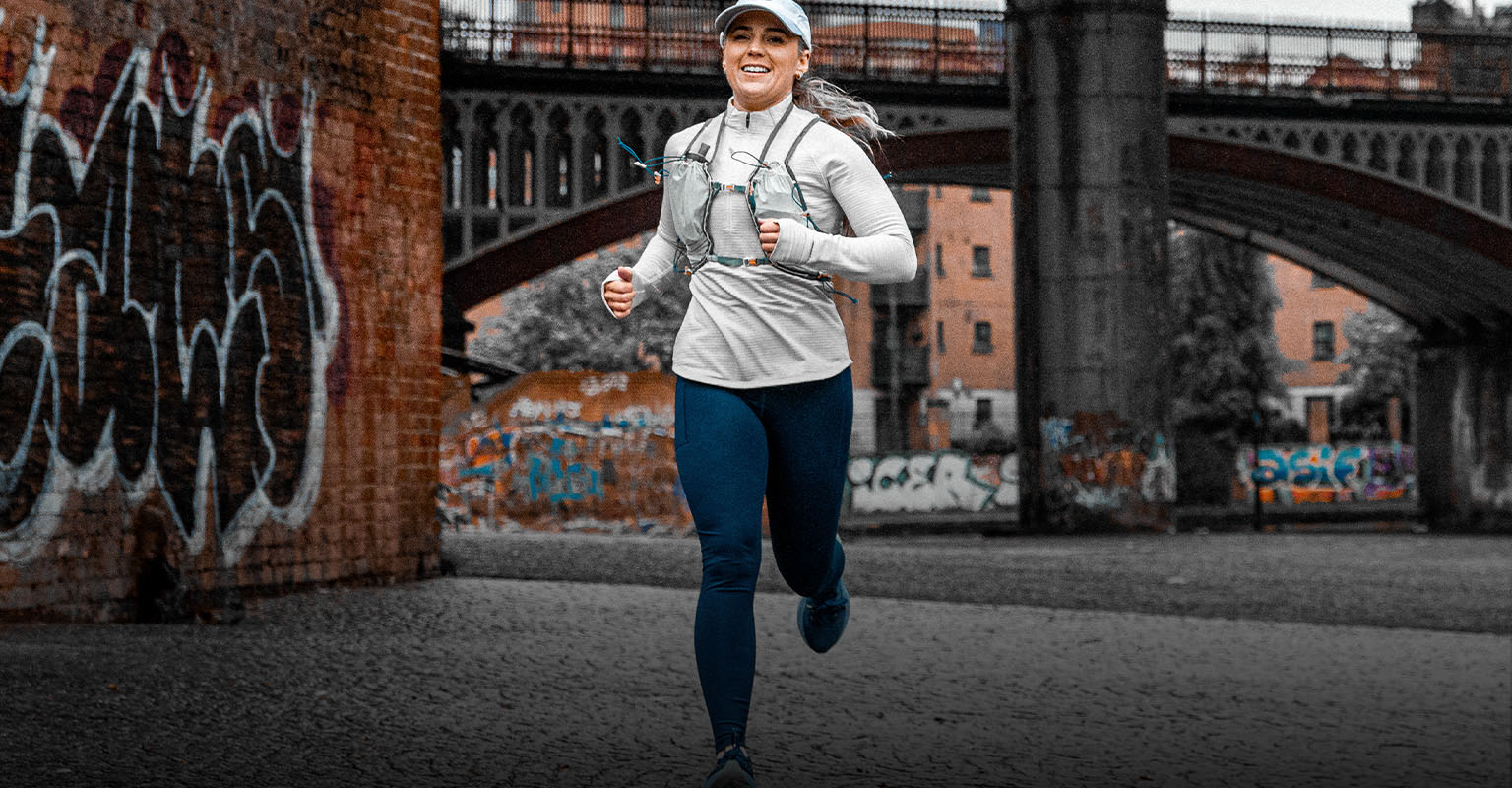 Shop women's running gear. A woman running on the street