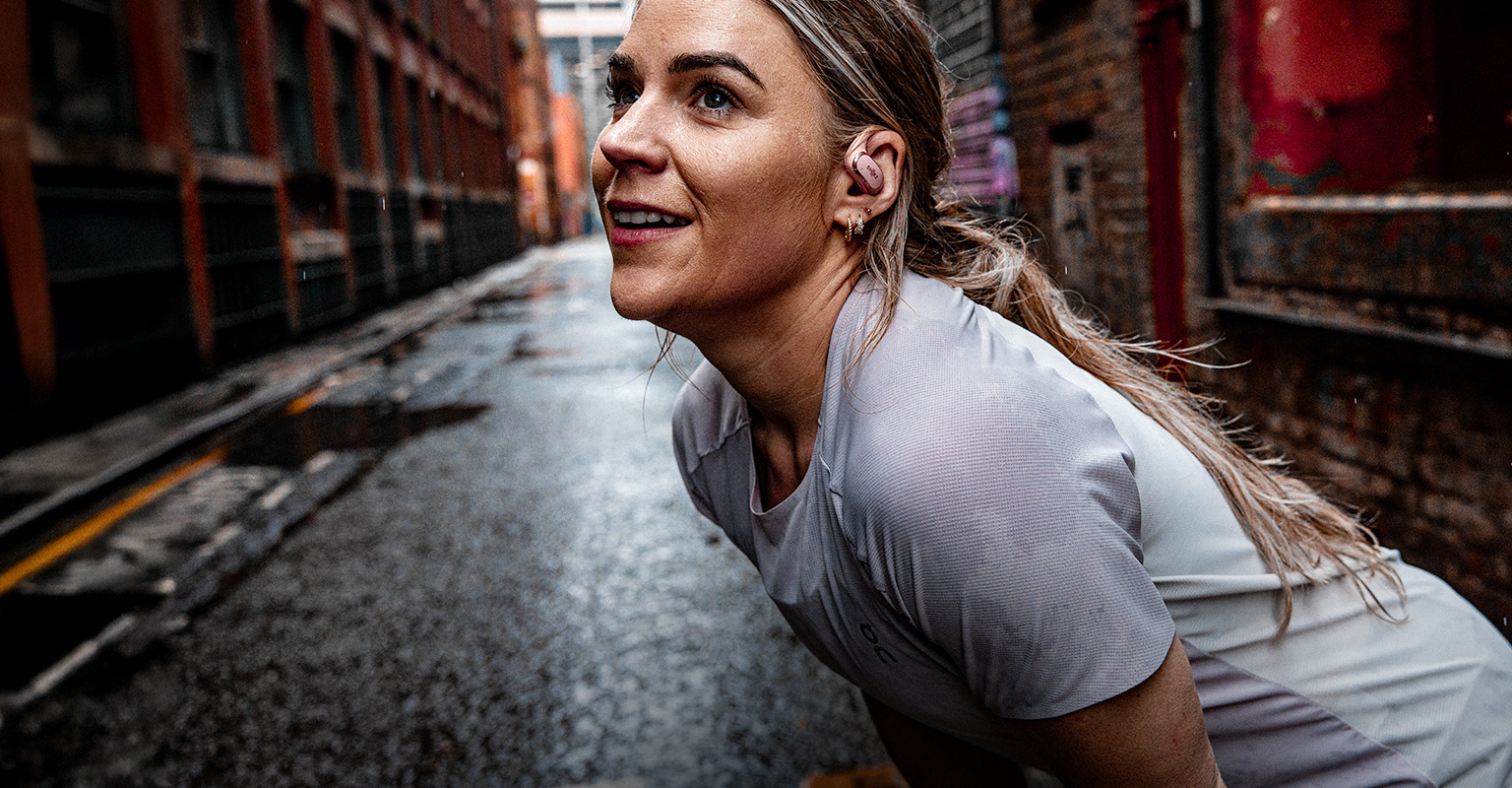 Shop women's running gear. A woman taking a rest after run on the street